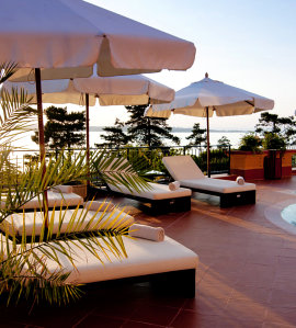 single bed beside the pool with umbrella