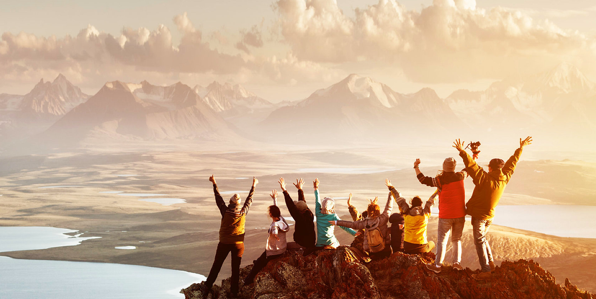 group of people at the top of the mountain facing the view