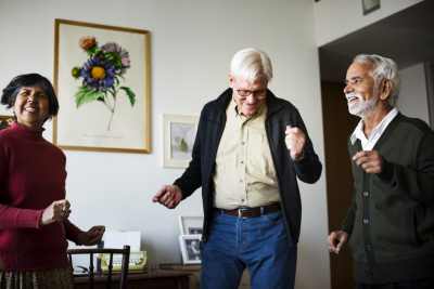 Senior people dancing together in a living room