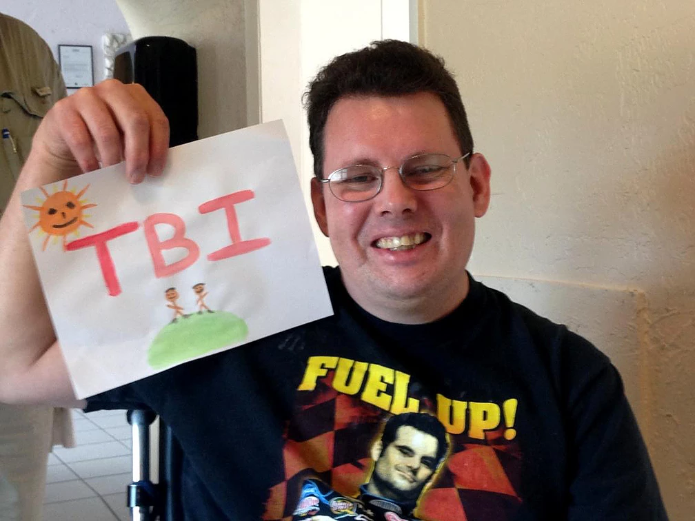 a happy man showing his artwork